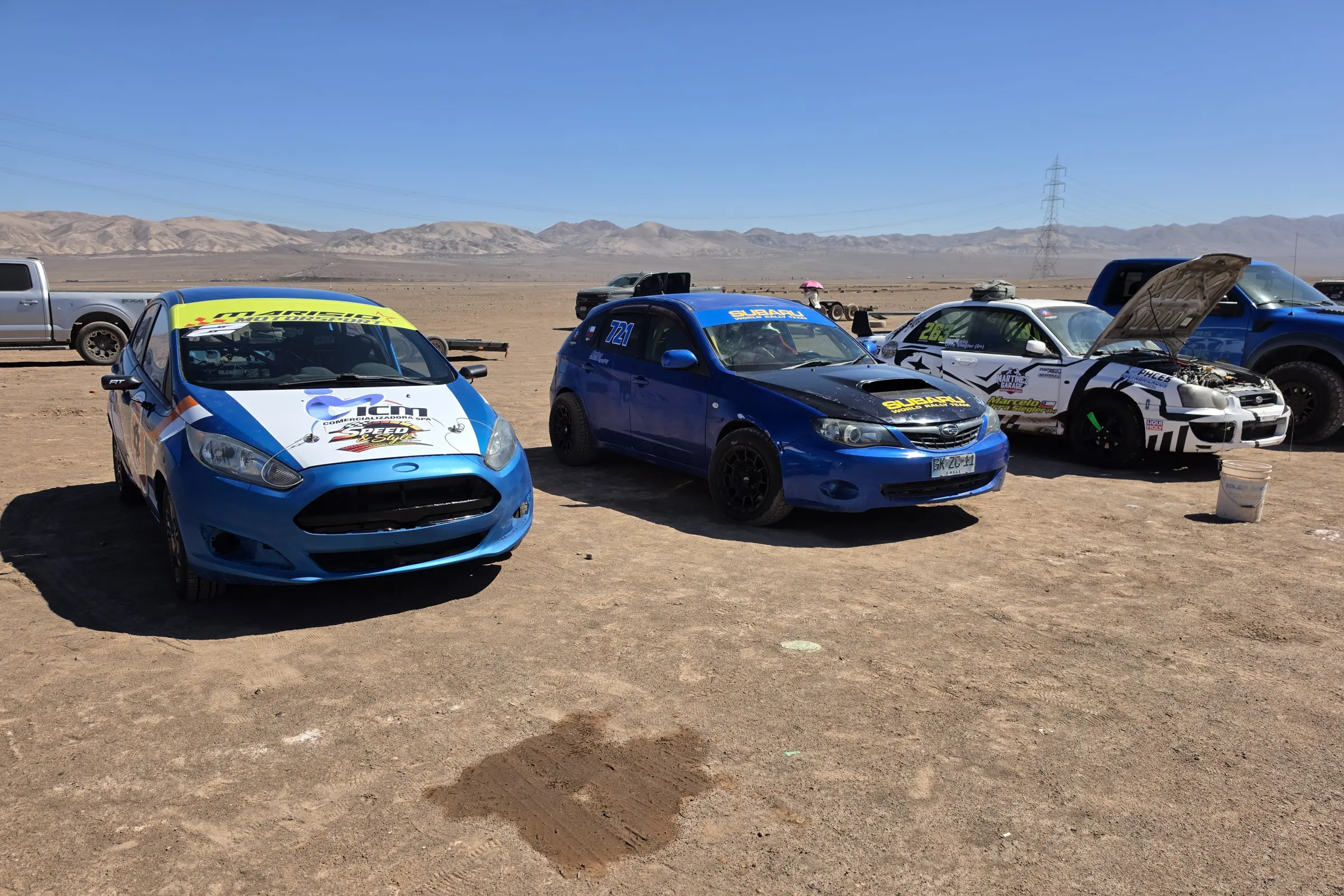 Autos de competición estacionados en el desierto